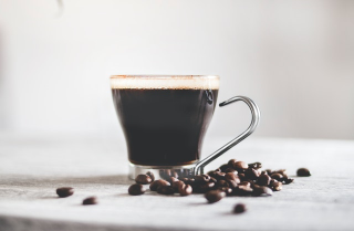 Cup of black coffee and coffee beans